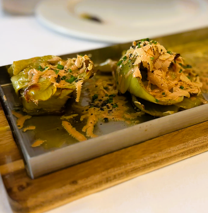 Restaurante Andrea. Antes de mais este é um restaurante muito procurado pelo que convém marcar para conseguir uma mesa. Comer neste maravilhoso restaurante do Principado de Andorra foi incrível e enorme prazer para quem aprecia boa comida. Para começar a simpatia de todas as pessoas que trabalham neste restaurante, começando pela dona Andrea que nos presenteou com uma simpatia sem igual. A atmosfera do restaurante é leve e calma para tornar qualquer refeição ainda melhor. Tem uma ótima seleção de vinhos, incluindo vinhos de Portugal. Começamos com um aperitivo de cortesia, uma delícia que incluiu umas miniespetadas de tomate cherry com presunto assado. Comemos alcachofras assadas com foie gras e nunca provei nada assim, cada dentada sentia a fusão dos sabores e a alcachofra a derreter-se na boca. Comemos um tártaro de vitela sobre uma camada de batatas fritas, incrível! No ponto! Ainda nas entradas também comemos Bao recheado com pequenas navalheiras fritas, o tempero com uma pequena acidez, uma delícia, gostava de repetir já. 😅 Já quase cheios, mas tínhamos de provar mais e ainda bem, continuamos com um arroz de lavagante caldoso como nunca comi, no ponto, o sabor, a quantidade generosa de lavagante. O lavagante cozinhado na perfeição. Também repetia já. 😍 Não paramos por aqui e comemos um prato de carne. Um delicioso Tomahawk na pedra quente, veio a carne previamente selada e partida em fatias fininhas para quem quisesse cozinhar um pouco mais na pedra quente. Para finalizar comemos um tiramisu que estava ótimo. No entanto, a estrela sem dúvida foi a premiada tarte de queijo, deliciosa, a textura, o sabor em que realmente se nota o sabor a queijo na quantidade certa. Foi toda uma experiência. Aconselho muito. Vale mesmo a pena para quem gosta de comer, tanto os pratos de arroz de conforto como comida inovadora. Obrigada querida Andrea por este maravilhoso canto gastronómico e pela sua simpatia!!!! Comida: 5/5Servicio: 5/5Ambiente: 5/5 Obrigado, Sara B Silva. Estamos profundamente agradecidos pela sua avaliação tão detalhada, generosa e cheia de entusiasmo — é um verdadeiro prazer ler a sua experiência no Restaurant Andrea, em La Massana. A sua descrição valoriza exatamente aquilo que procuramos oferecer todos os dias: – uma cozinha de alto nível, onde brilham os nossos arrozes de marisco, como o arroz de lavagante azul fresco, preparado sempre no ponto; – peixes frescos e mariscos de luxo, trabalhados com rigor e respeito pelo produto; – carnes selecionadas, como o nosso Tomahawk, servidas com a técnica e o cuidado que mencionou; – e uma combinação entre pratos tradicionais, propostas inovadoras e sabores que surpreendem. Ficamos igualmente felizes por destacar a simpatia da equipa e da Andrea, a atmosfera tranquila do restaurante e a qualidade das nossas entradas — desde as alcachofras assadas com foie gras até ao tártaro de vitela e aos vãos de navalheiras. É maravilhoso saber que cada prato lhe proporcionou uma experiência memorável. A nossa excelente adega, com referências de várias origens, incluindo vinhos de Portugal, é um dos nossos grandes orgulhos, e é ótimo saber que também apreciou essa parte da experiência. E, claro, os postres casolans merecem sempre um lugar especial. Em particular, o nosso pastís de formatge, a tarta de queso casera premiada como a melhor de Andorra, que descreveu tão bem — cremosa, equilibrada e com o sabor autêntico do queijo no ponto certo. “El pastís de formatge és la nostra joia de la corona, fet cada dia amb dedicació i reconegut com el millor d’Andorra.” Muito obrigado, de coração, por recomendar o nosso “canto gastronómico” e por valorizar o trabalho de toda a equipa. Será sempre um prazer recebê-la novamente no Restaurant Andrea. 