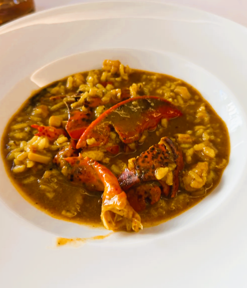 Restaurante Andrea. Antes de mais este é um restaurante muito procurado pelo que convém marcar para conseguir uma mesa. Comer neste maravilhoso restaurante do Principado de Andorra foi incrível e enorme prazer para quem aprecia boa comida. Para começar a simpatia de todas as pessoas que trabalham neste restaurante, começando pela dona Andrea que nos presenteou com uma simpatia sem igual. A atmosfera do restaurante é leve e calma para tornar qualquer refeição ainda melhor. Tem uma ótima seleção de vinhos, incluindo vinhos de Portugal. Começamos com um aperitivo de cortesia, uma delícia que incluiu umas miniespetadas de tomate cherry com presunto assado. Comemos alcachofras assadas com foie gras e nunca provei nada assim, cada dentada sentia a fusão dos sabores e a alcachofra a derreter-se na boca. Comemos um tártaro de vitela sobre uma camada de batatas fritas, incrível! No ponto! Ainda nas entradas também comemos Bao recheado com pequenas navalheiras fritas, o tempero com uma pequena acidez, uma delícia, gostava de repetir já. 😅 Já quase cheios, mas tínhamos de provar mais e ainda bem, continuamos com um arroz de lavagante caldoso como nunca comi, no ponto, o sabor, a quantidade generosa de lavagante. O lavagante cozinhado na perfeição. Também repetia já. 😍 Não paramos por aqui e comemos um prato de carne. Um delicioso Tomahawk na pedra quente, veio a carne previamente selada e partida em fatias fininhas para quem quisesse cozinhar um pouco mais na pedra quente. Para finalizar comemos um tiramisu que estava ótimo. No entanto, a estrela sem dúvida foi a premiada tarte de queijo, deliciosa, a textura, o sabor em que realmente se nota o sabor a queijo na quantidade certa. Foi toda uma experiência. Aconselho muito. Vale mesmo a pena para quem gosta de comer, tanto os pratos de arroz de conforto como comida inovadora. Obrigada querida Andrea por este maravilhoso canto gastronómico e pela sua simpatia!!!! Comida: 5/5Servicio: 5/5Ambiente: 5/5 Obrigado, Sara B Silva. Estamos profundamente agradecidos pela sua avaliação tão detalhada, generosa e cheia de entusiasmo — é um verdadeiro prazer ler a sua experiência no Restaurant Andrea, em La Massana. A sua descrição valoriza exatamente aquilo que procuramos oferecer todos os dias: – uma cozinha de alto nível, onde brilham os nossos arrozes de marisco, como o arroz de lavagante azul fresco, preparado sempre no ponto; – peixes frescos e mariscos de luxo, trabalhados com rigor e respeito pelo produto; – carnes selecionadas, como o nosso Tomahawk, servidas com a técnica e o cuidado que mencionou; – e uma combinação entre pratos tradicionais, propostas inovadoras e sabores que surpreendem. Ficamos igualmente felizes por destacar a simpatia da equipa e da Andrea, a atmosfera tranquila do restaurante e a qualidade das nossas entradas — desde as alcachofras assadas com foie gras até ao tártaro de vitela e aos vãos de navalheiras. É maravilhoso saber que cada prato lhe proporcionou uma experiência memorável. A nossa excelente adega, com referências de várias origens, incluindo vinhos de Portugal, é um dos nossos grandes orgulhos, e é ótimo saber que também apreciou essa parte da experiência. E, claro, os postres casolans merecem sempre um lugar especial. Em particular, o nosso pastís de formatge, a tarta de queso casera premiada como a melhor de Andorra, que descreveu tão bem — cremosa, equilibrada e com o sabor autêntico do queijo no ponto certo. “El pastís de formatge és la nostra joia de la corona, fet cada dia amb dedicació i reconegut com el millor d’Andorra.” Muito obrigado, de coração, por recomendar o nosso “canto gastronómico” e por valorizar o trabalho de toda a equipa. Será sempre um prazer recebê-la novamente no Restaurant Andrea.
